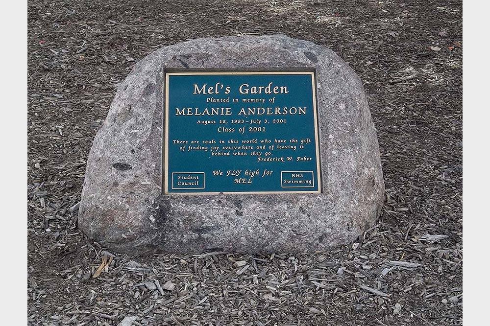 Bronze plaque with script font on a boulder