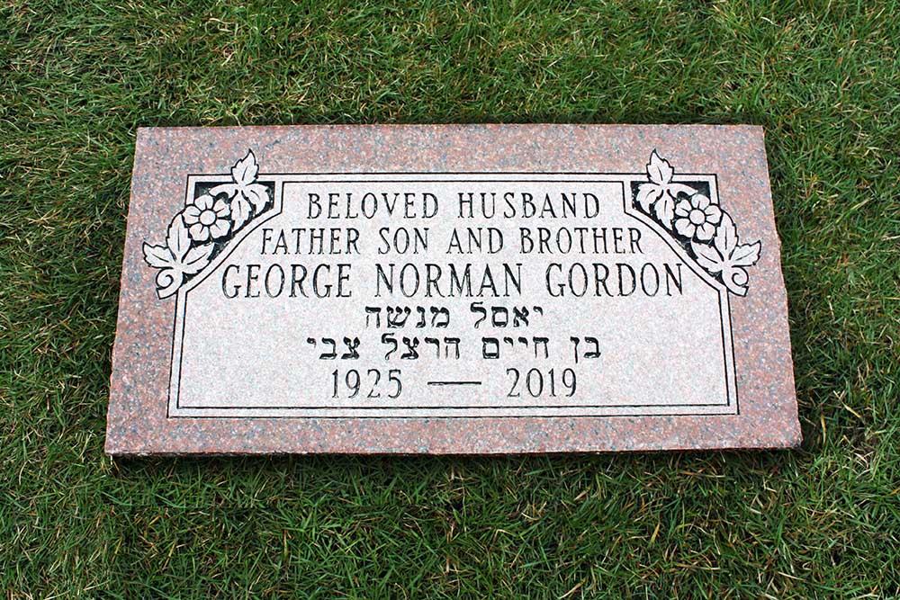 Red granite marker with Hebrew roses