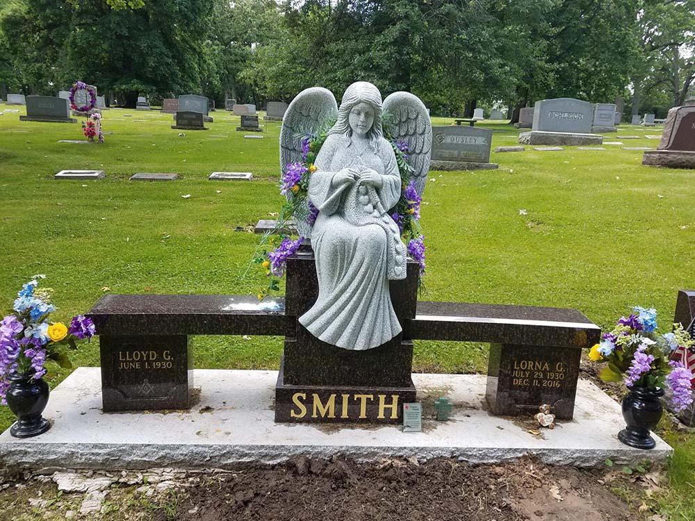 Bench monument with angel on a granite fountain