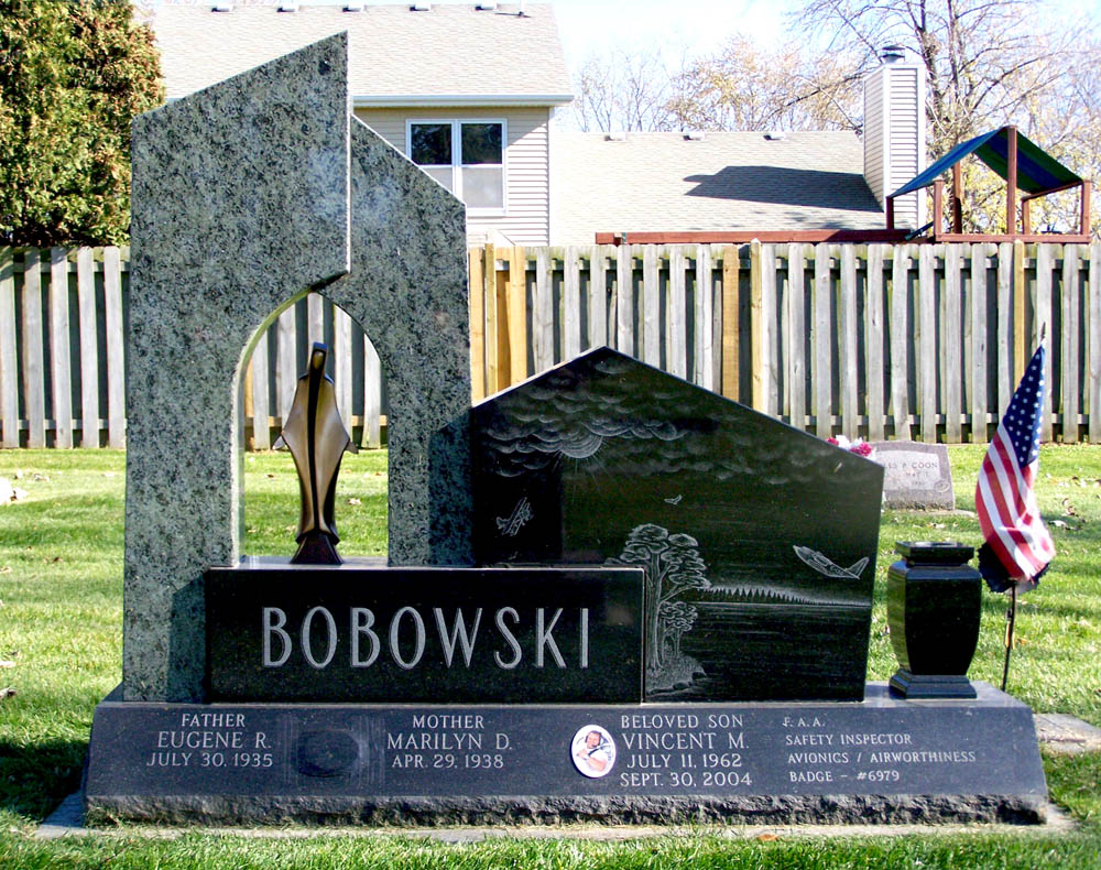 Black family monument with green granite accent and a bronze statue of Mary